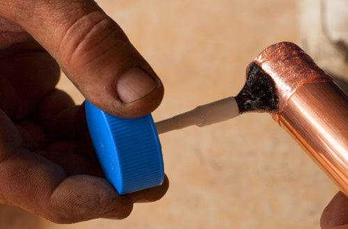 Applying flux to a copper pipe